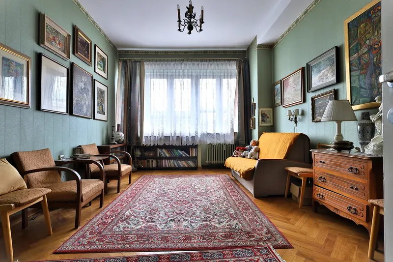 Pokój z galerią obrazów, żyrandolem i dywanem w kamienicy